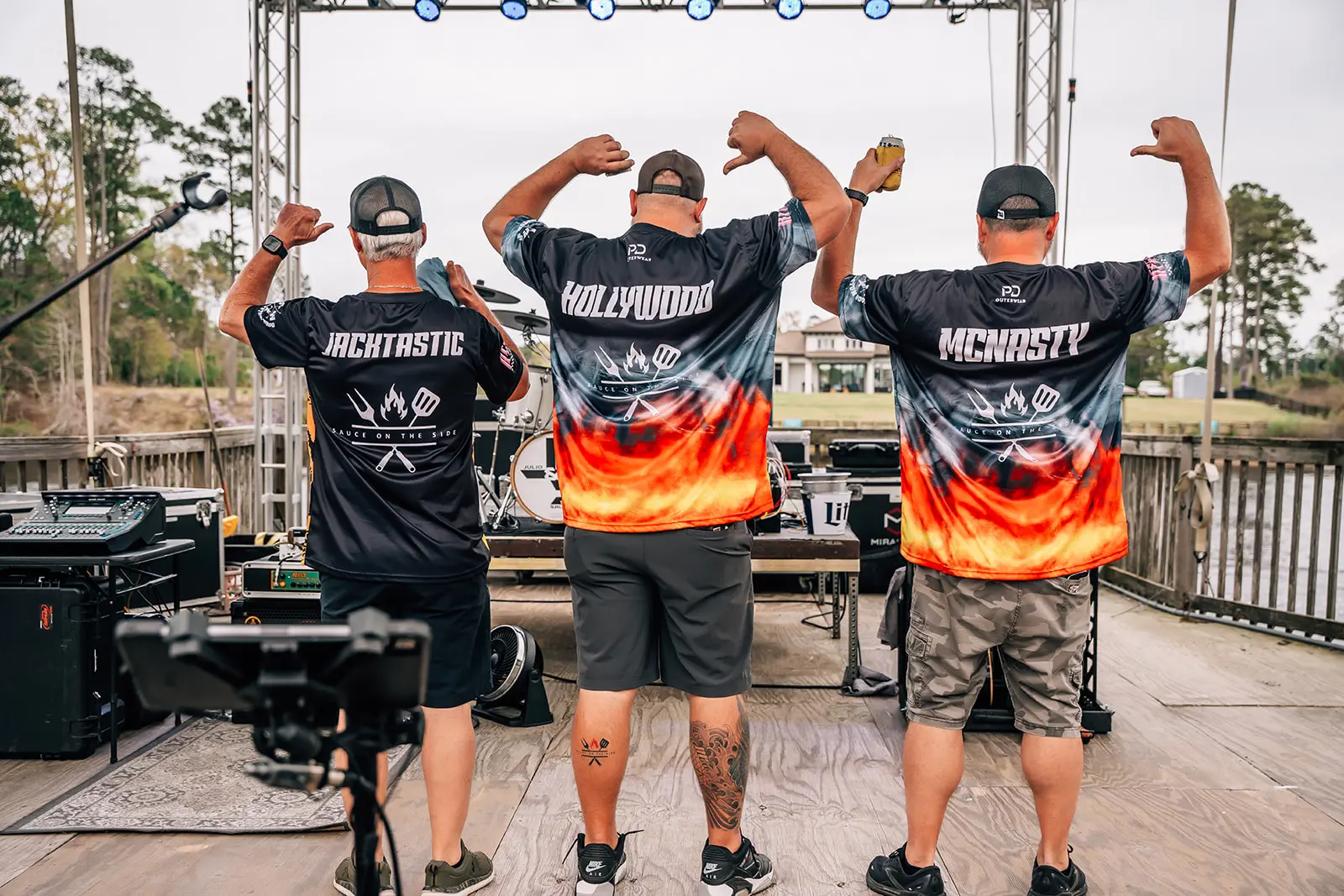 Guys on stage showing off their shirts