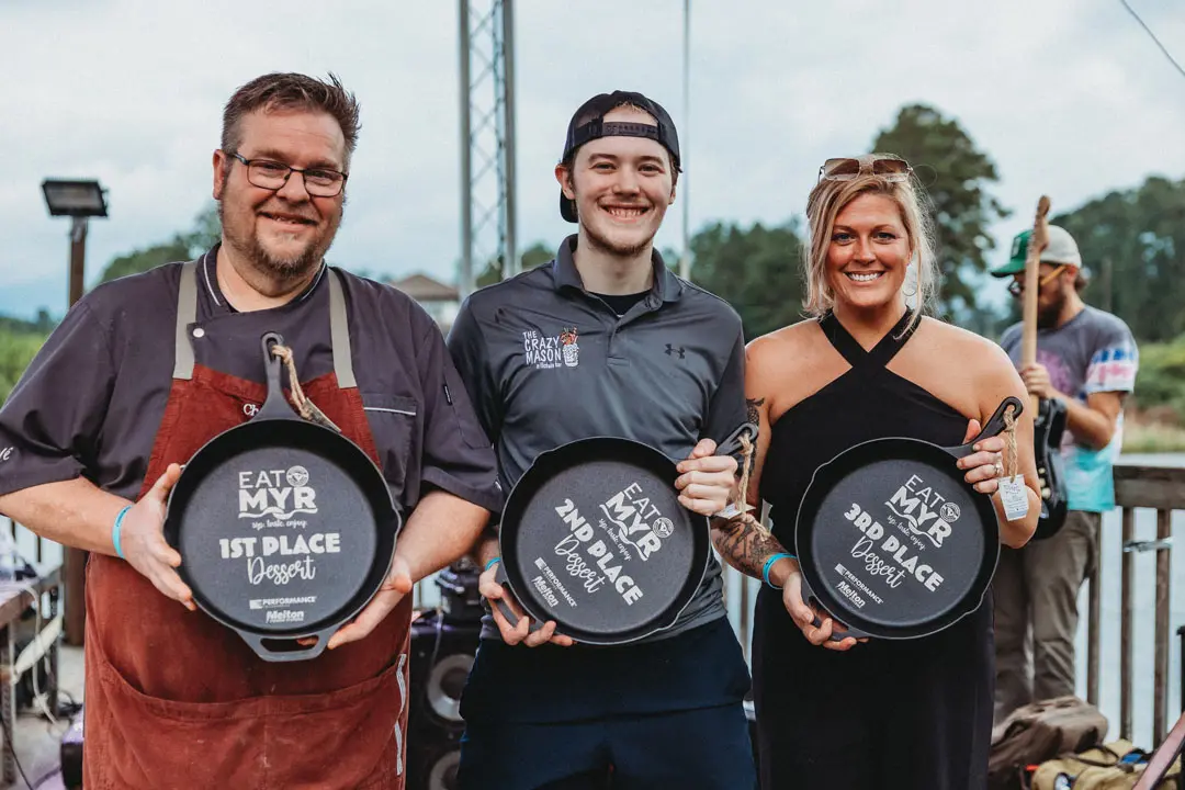 3 people holding awards
