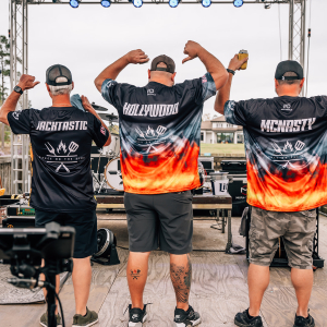 Guys on stage showing off their shirts